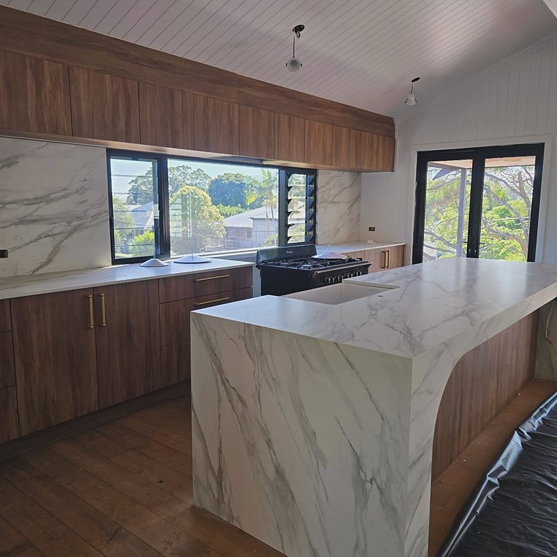 Timber kitchen with marble waterfall island and treetop views