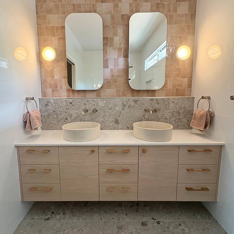 Bathroom vanity with twin stone basins and terracotta tiles