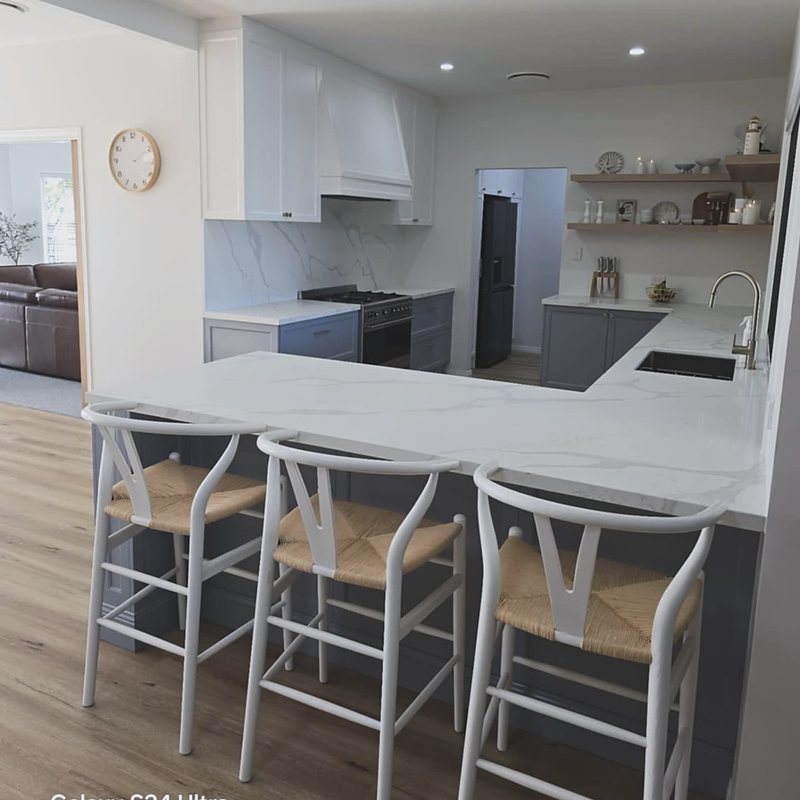 White kitchen with island seating and open shelving